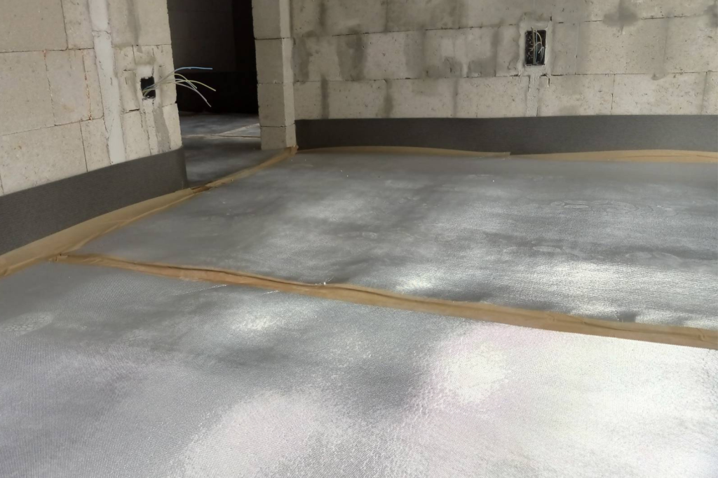 Vloerisolatieplaten nauwkeurig gelegd op de betonvloer van een nieuwbouwwoning, klaar voor het storten van de chape.